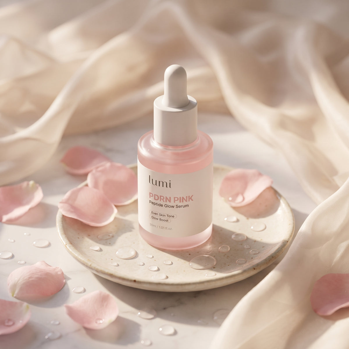 Lumi PDRN Pink Peptide Glow Serum bottle on a ceramic dish surrounded by pink rose petals and water droplets